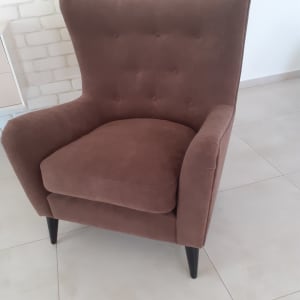 כורסה חומה מרופדת עם רגליים שחורות