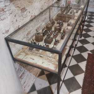 ויטרינה מזכוכית עם תכשיטים על מדף עץ