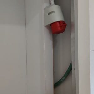 שקע תעשייתי אדום מותקן בקיר עם צינור חשמל