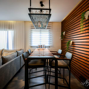 שולחן עץ עם כיסאות, קיר עץ עם צמחים תלויים