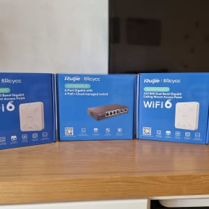 שלוש קופסאות של נקודות גישה ומתג רשת על מדף