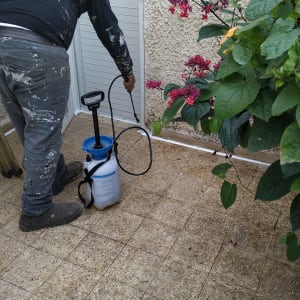 אדם מרסס חומר איטום על רצפה ליד דלת