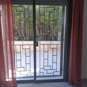 חלון עם מסגרת מתכת ודלת זכוכית