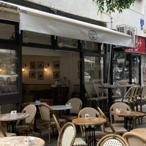 סוכך לבן פתוח מעל בית קפה