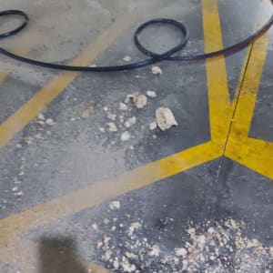 צינור שחור על רצפה עם אבק ולכלוך