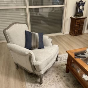 כורסה מרופדת עם כרית פסים על שטיח