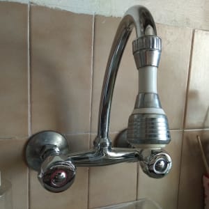 ברז מטבח עם ידית מתכת וכפתורי שליטה