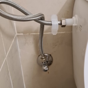 צינור מתכת מחובר לשירותים עם ברז