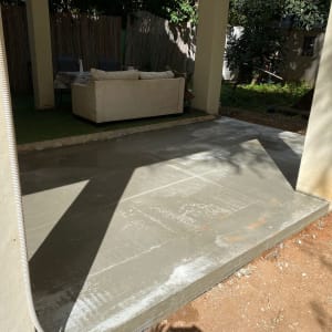 רצפת בטון חדשה תחת פרגולה בחצר