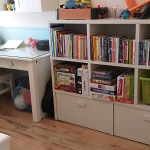 מדף עם ספרים, משחקים וצעצועים בחדר ילדים
