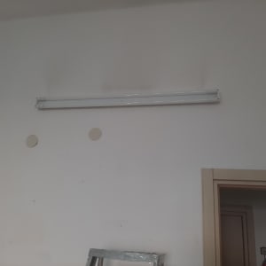 גוף תאורה פלורסנט מותקן על קיר לבן