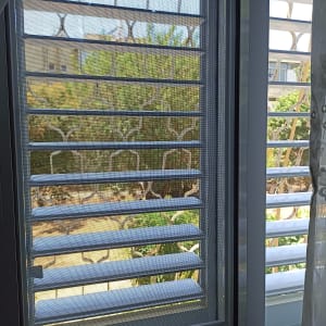 תריסי אלומיניום בחלון עם רשת