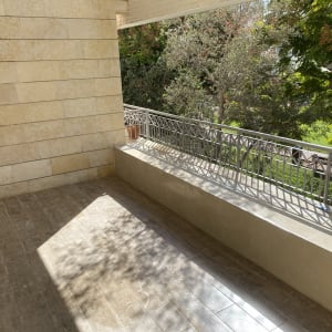 מרפסת עם רצפת עץ וקיר אבן