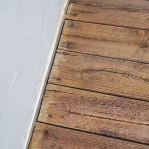 רצפת עץ חומה ליד קיר לבן