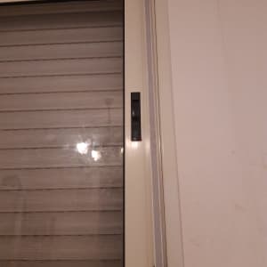 תריסים סגורים עם ידית שחורה על מסגרת לבנה