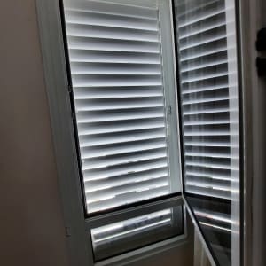 חלון אלומיניום עם תריסים פתוחים למחצה