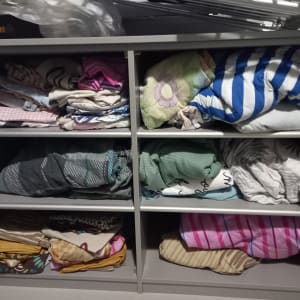 מדפים עם מצעים מקופלים בצבעים שונים