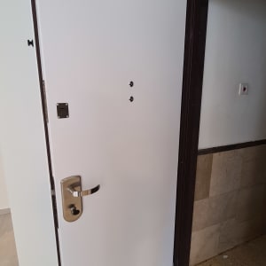 דלת לבנה עם ידית מתכת כסופה