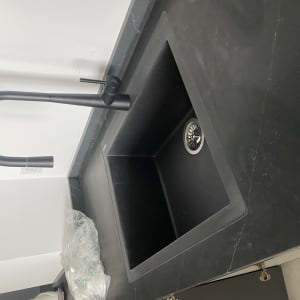 כיור שחור עם ברז מעוקל על משטח עבודה