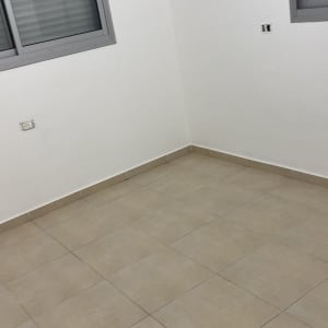 קיר לבן עם חלון ואריחי רצפה