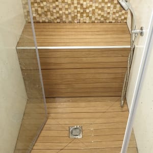 מקלחון עם רצפת עץ ואריחי קיר מעוצבים