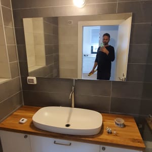 מראה מלבנית תלויה על קיר בחדר אמבטיה