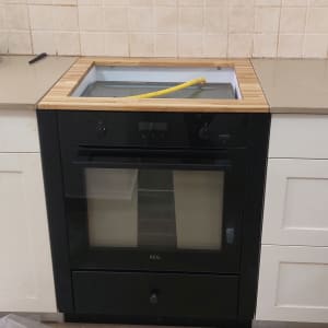 תנור שחור מותקן במטבח עם צינור גז צהוב