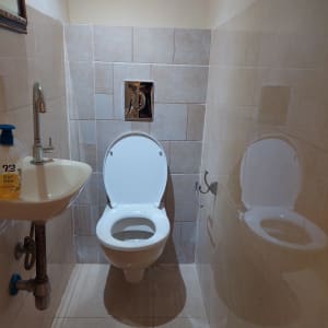 שירותים עם אסלה, כיור וברז, צנרת גלויה