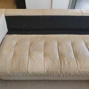 ספה בהירה עם כתמים על המושב והמשענת