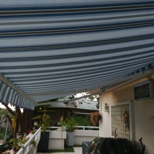 סוכך פסים כחול לבן מותקן מעל מרפסת