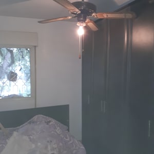 מאוורר תקרה עם מנורה דולקת בחדר שינה