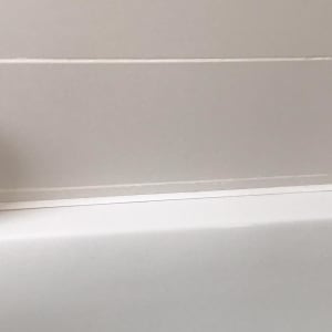 חיבור בין אמבטיה לקיר עם אריחים לבנים