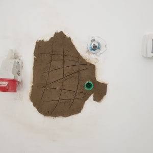 קיר עם חור ותשתית צנרת חשופה