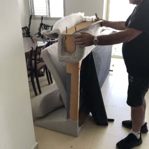 אדם מרפד ספה עם בד ומסמרים