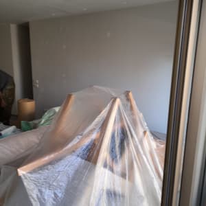 חדר עם קירות צבועים, רהיטים מכוסים בניילון