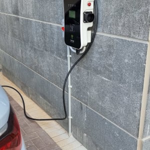 עמדת טעינה לרכב חשמלי מותקנת על קיר אבן