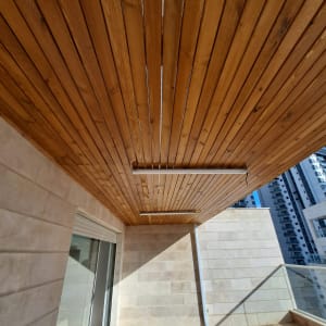 תקרה מעץ עם תאורה על מרפסת מרוצפת עץ