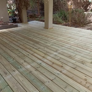 דק עץ חדש בגינה עם עמודים ותאורה