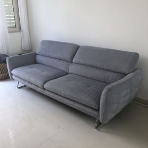 ספה אפורה על רצפה בהירה ליד חלון