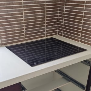 משטח שיש לבן עם כיריים שחורות מובנות