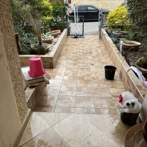 דלי שחור, מגב ורצפה רטובה בכניסה לבית