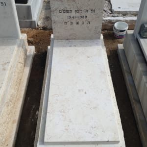 מצבה לבנה עם כיתוב בעברית בבית קברות