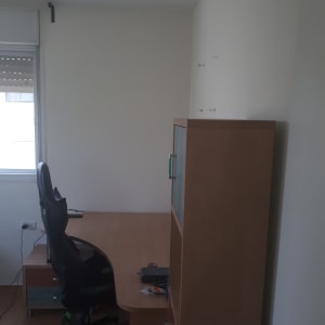 קיר לבן עם ברגים בולטים, שולחן וכיסא