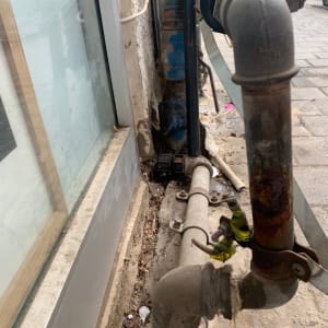 צינור מתכת חלוד עם ברז ליד קיר