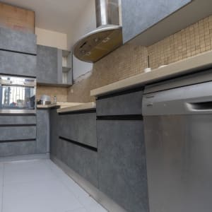 מטבח עם ארונות אפורים ומכשירי חשמל