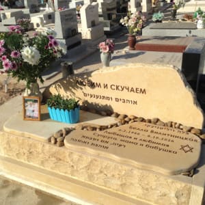 קבר עם מצבה ופרחים בבית קברות