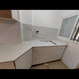 מטבח עם משטחי שיש לבן ודלפקים