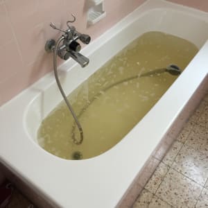 אמבטיה עם מים עכורים וברז מתכת