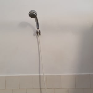 קיר צבוע חלקית בצבע לבן ליד מקלחת