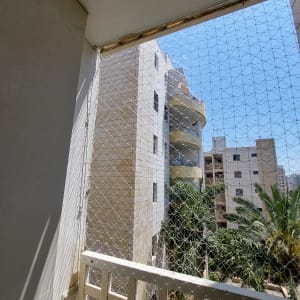 רשת הגנה מותקנת על מרפסת למניעת כניסת יונים